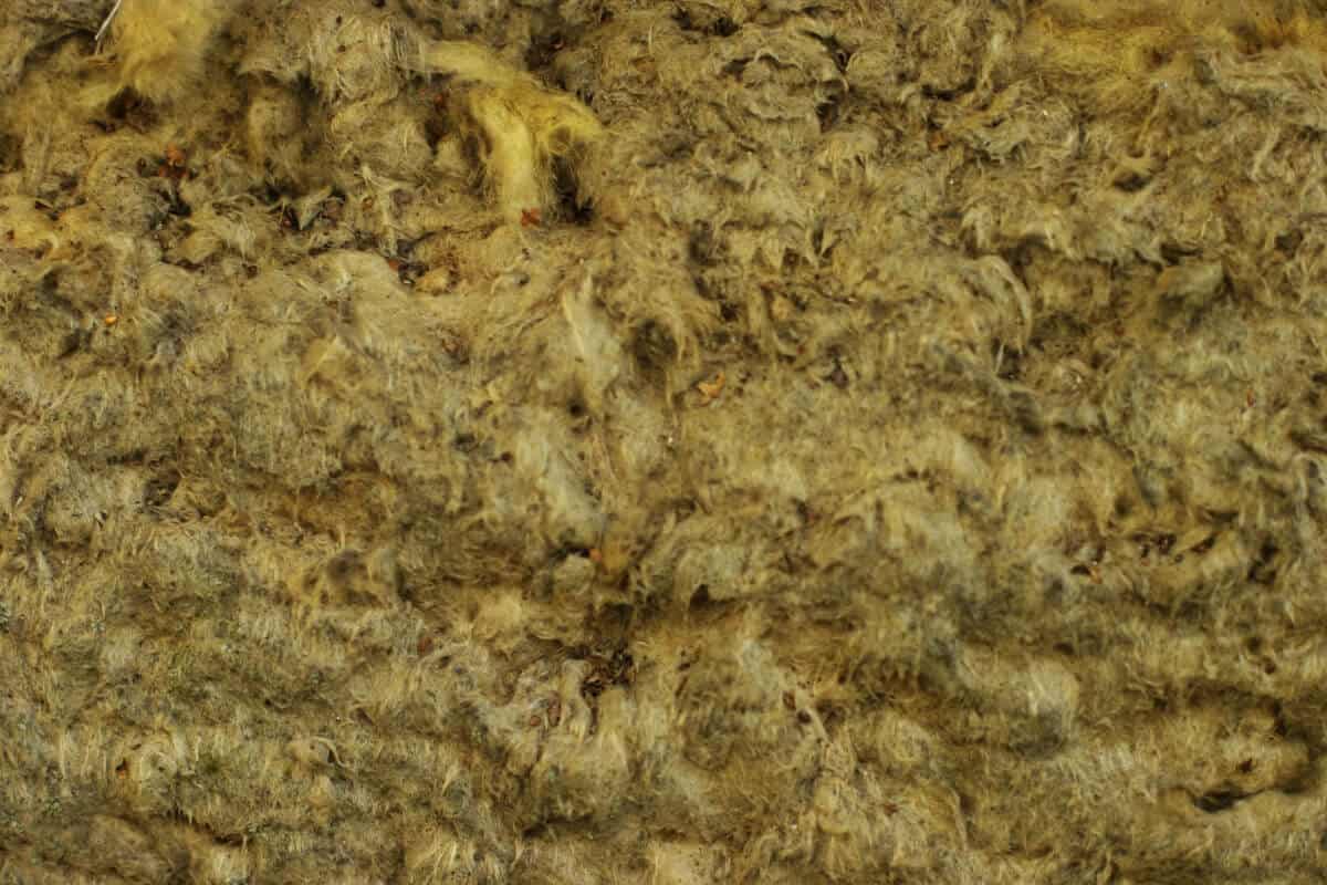 Close-up view of a fibrous, rough-textured rockwool in various shades of beige and brown.