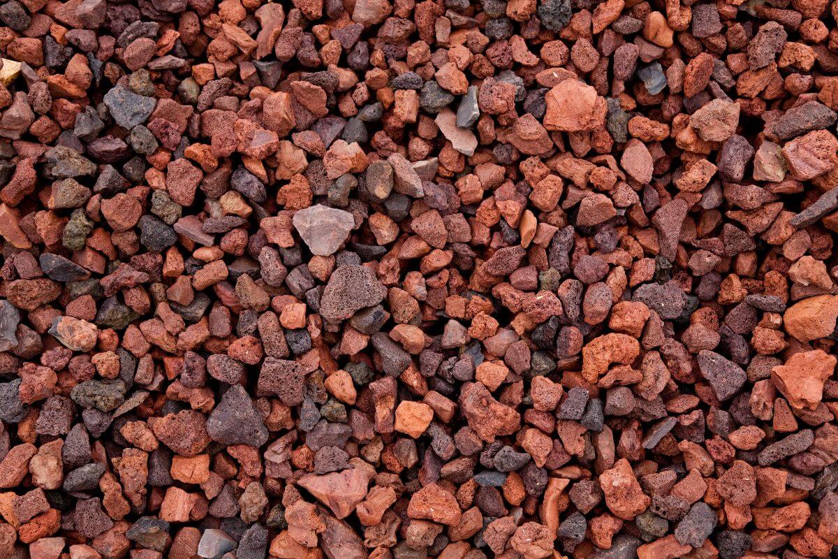 A close-up view of a pile of small, irregularly shaped, reddish-brown hydroponic lava rocks.