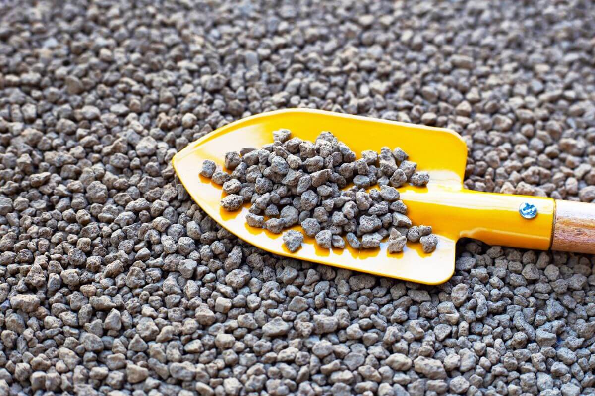 Akadama, a clay-like mineral commonly used in bonsai soil mix, with a yellow trowel holding a small scoop of it.