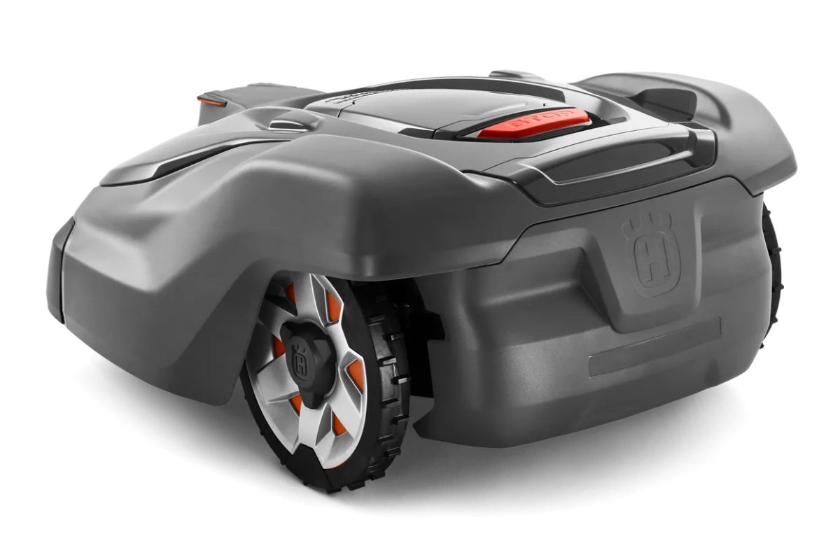 The Husqvarna Automower 430XH is a sleek, modern robotic lawn mower with a black and gray body, featuring rugged wheels with orange accents. 