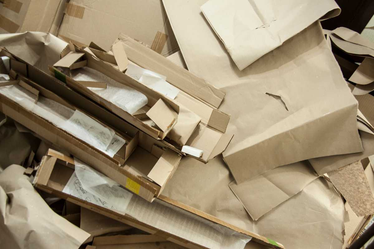 A messy pile of crumpled and folded cardboard and brown paper sheets, some of which are torn or partially ripped. The stacked pieces appear to be discarded packaging materials.