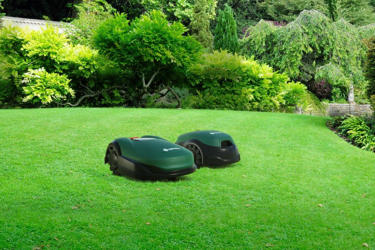 Image of Two Robomow models seen operating on a lush green lawn.