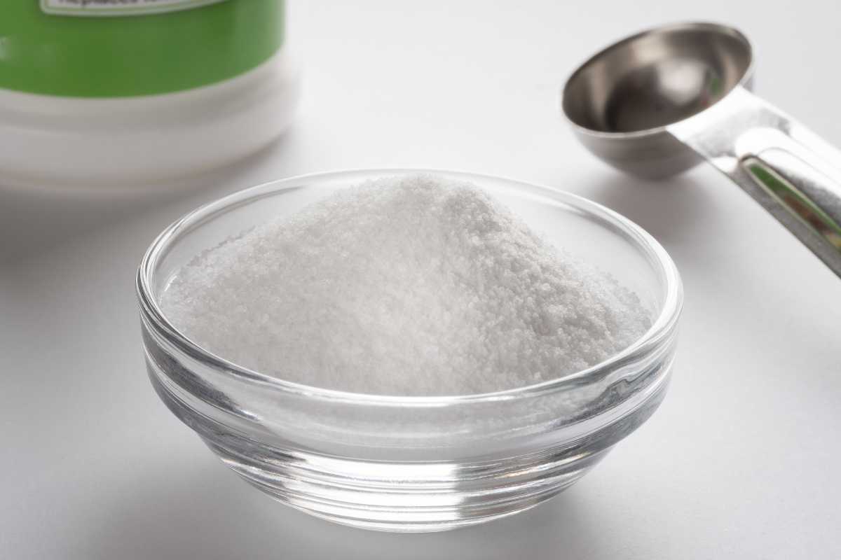 A small, clear glass bowl filled with white, boric acid and sugar.