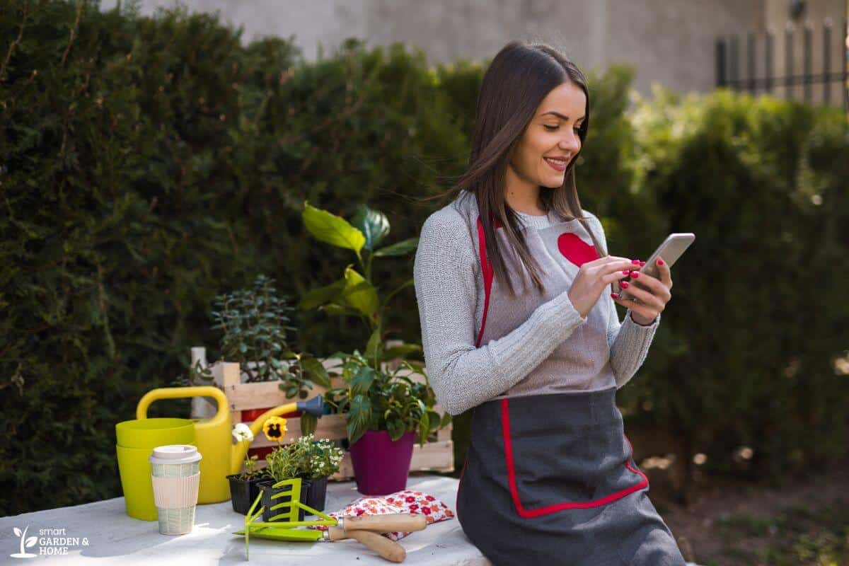 Girl Looking Through Phone While Gardening